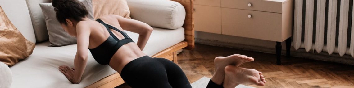 A woman stretches on a mat in a stylish living room, promoting a healthy lifestyle.